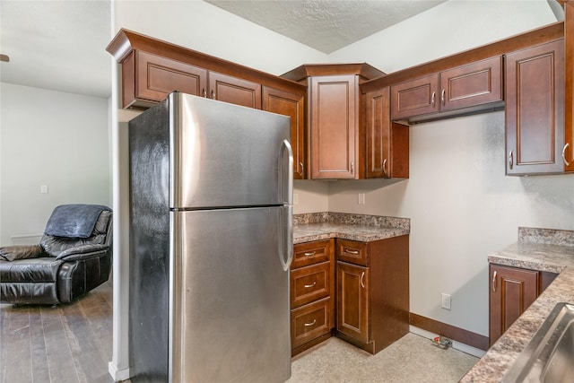 kitchen featuring stainless steel fridge, a textured ceiling, and sink