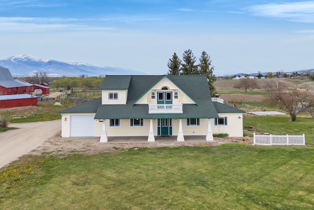 358 Hamilton Heights Rd, Corvallis, MT 59828 - view of front of house with a front lawn, a balcony, covered porch, dirt driveway, and an attached garage