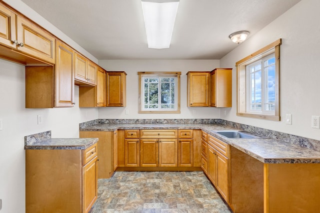 358 Hamilton Heights Rd, Corvallis, MT 59828 - kitchen with a sink, stone finish flooring, brown cabinetry, and a healthy amount of sunlight