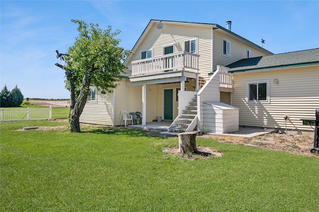 rear view of house featuring a yard, a patio, and a wooden deck