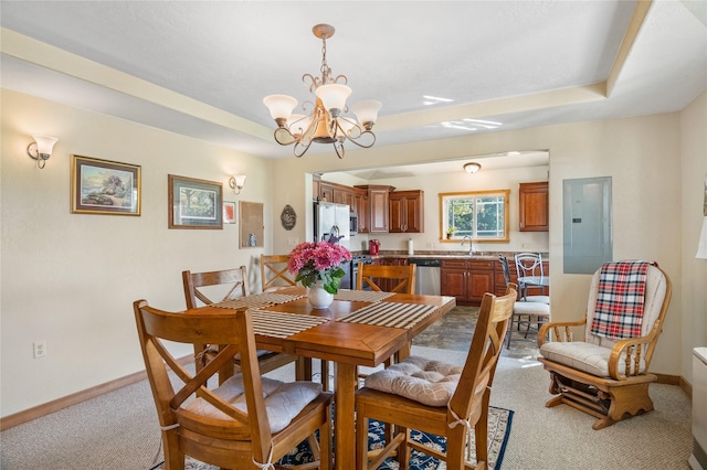 dining room featuring sink, electric panel, a chandelier, a tray ceiling, and light carpet