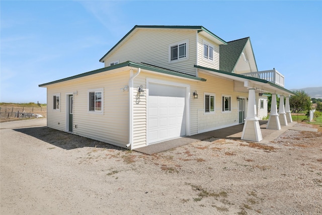 exterior space featuring a balcony, a porch, and a garage