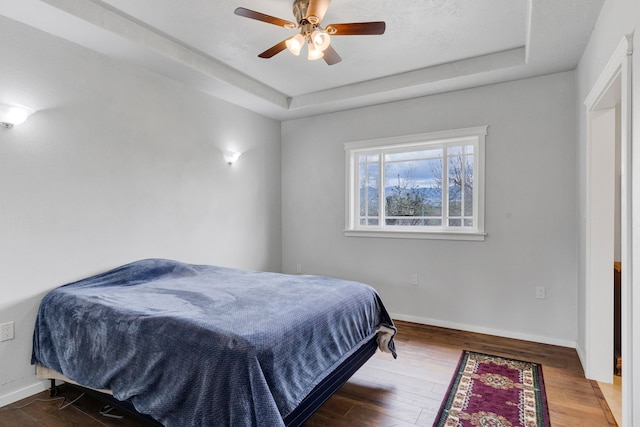 358 Hamilton Heights Rd, Corvallis, MT 59828 - bedroom featuring baseboards, a ceiling fan, a raised ceiling, and wood finished floors