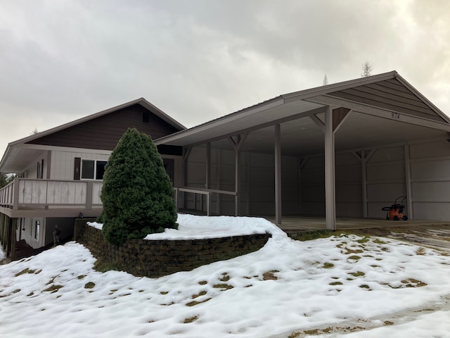 snow covered property featuring a balcony and a carport