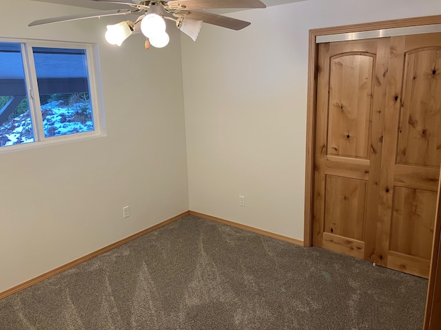 carpeted spare room featuring ceiling fan