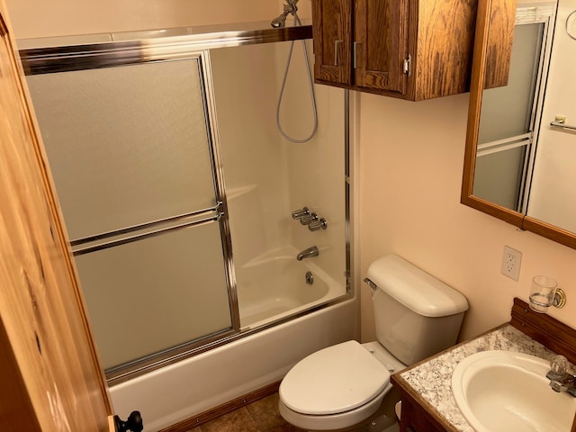 full bathroom with tile patterned floors, shower / bath combination with glass door, vanity, and toilet