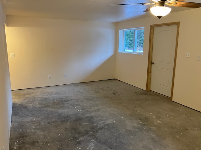 empty room with ceiling fan and concrete floors