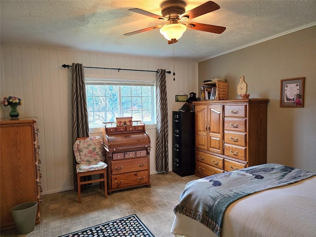 bedroom with ceiling fan, wooden walls, crown molding, and a textured ceiling