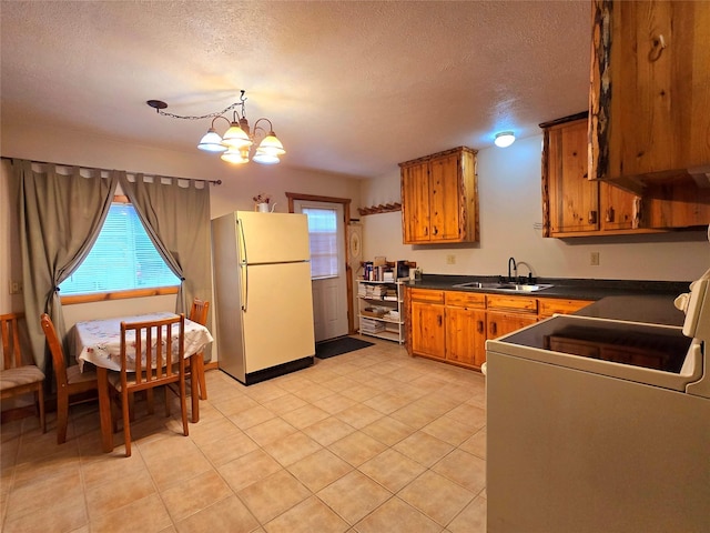 kitchen with sink, an inviting chandelier, white refrigerator, stove, and a textured ceiling