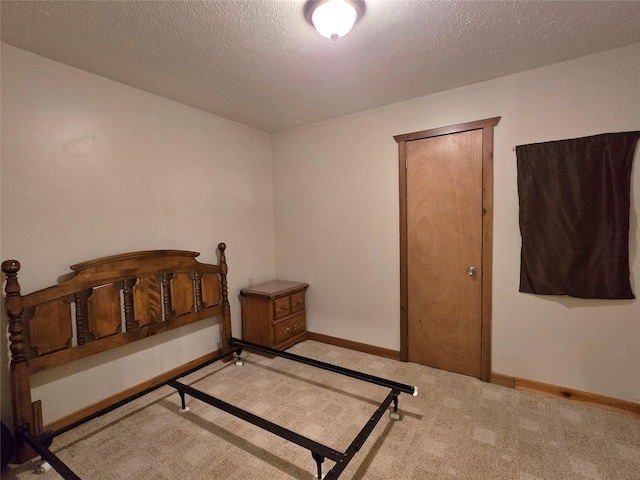 bedroom featuring light carpet and a textured ceiling