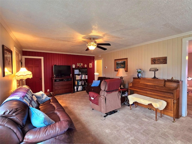 living room with a textured ceiling, light colored carpet, ceiling fan, and crown molding