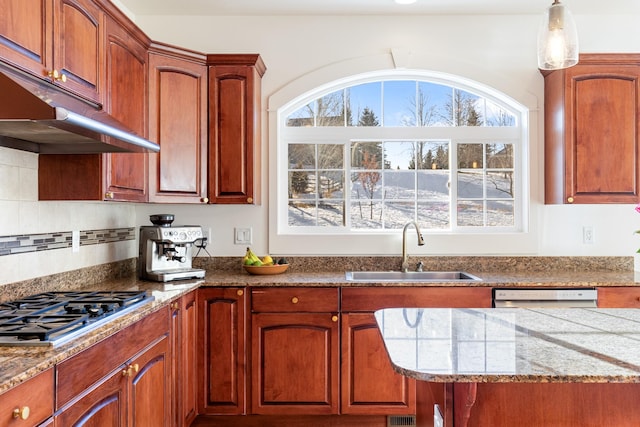 kitchen with appliances with stainless steel finishes, decorative light fixtures, tasteful backsplash, and sink