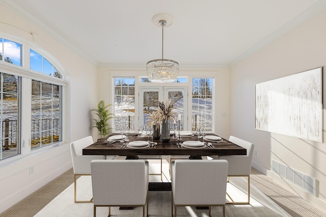 dining area with light carpet, ornamental molding, plenty of natural light, and a notable chandelier