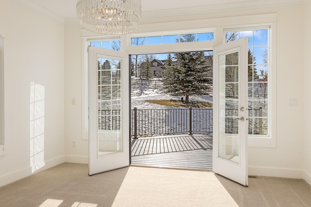 entryway featuring crown molding, french doors, light colored carpet, and a chandelier