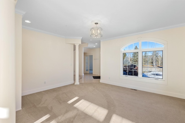 unfurnished room featuring light carpet, a chandelier, ornate columns, and ornamental molding