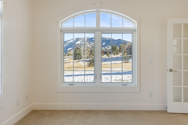 carpeted empty room with a mountain view and a wealth of natural light