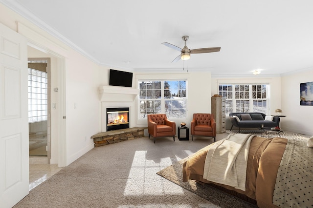 carpeted bedroom featuring a fireplace, ceiling fan, crown molding, and multiple windows