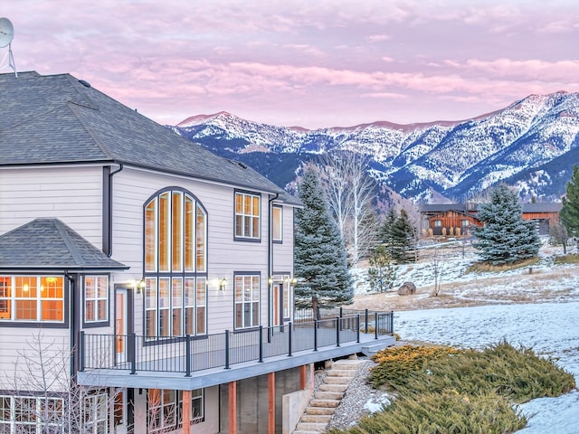 snow covered property featuring a deck with mountain view