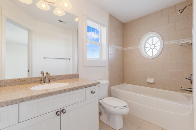 full bathroom featuring tile patterned flooring, vanity, toilet, and tiled shower / bath