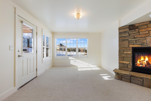 living room featuring a stone fireplace and light colored carpet