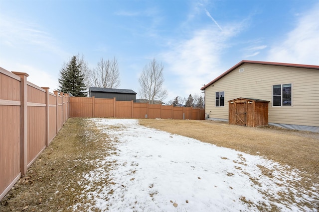 yard covered in snow with a storage shed