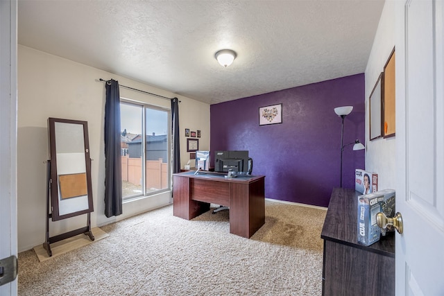 carpeted office space featuring a textured ceiling