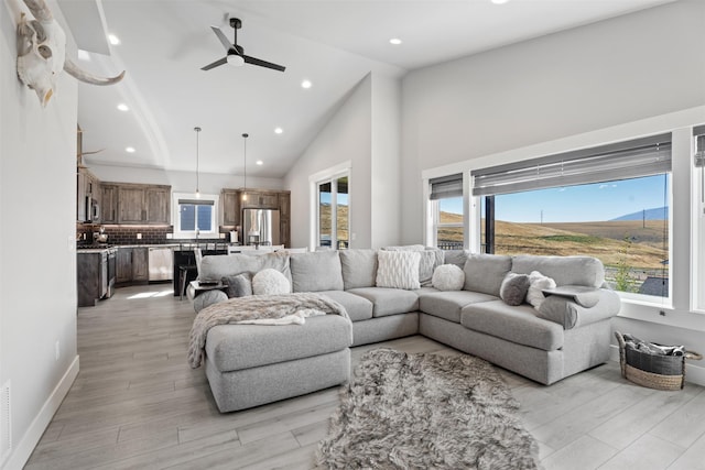 living room with high vaulted ceiling, a mountain view, light hardwood / wood-style floors, and ceiling fan