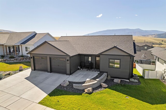 ranch-style house featuring a mountain view, a garage, and a front yard