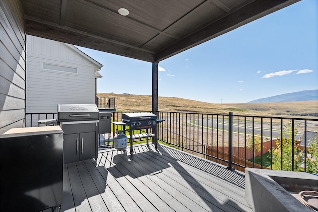 wooden deck featuring a mountain view and a grill