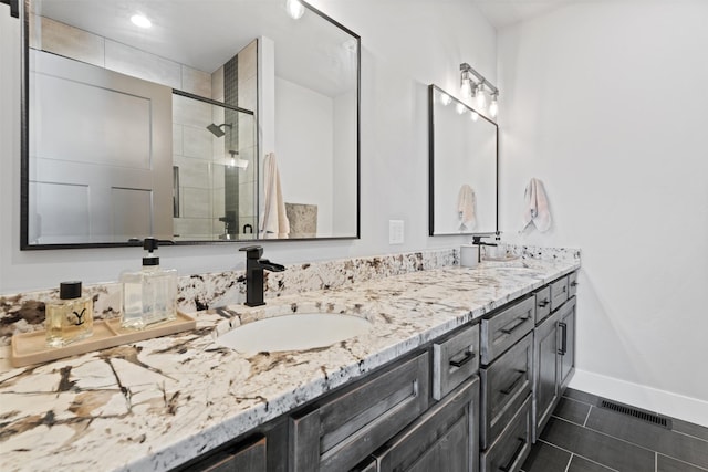 bathroom featuring tile patterned flooring, vanity, and a shower with shower door