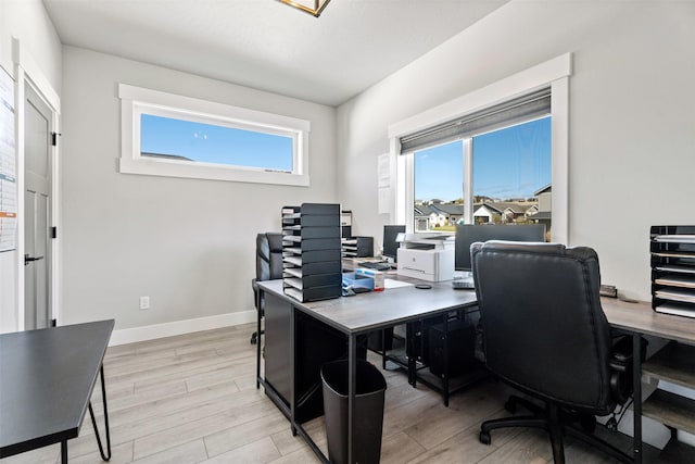 home office with a healthy amount of sunlight and light wood-type flooring