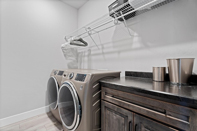 laundry area with separate washer and dryer and light hardwood / wood-style floors