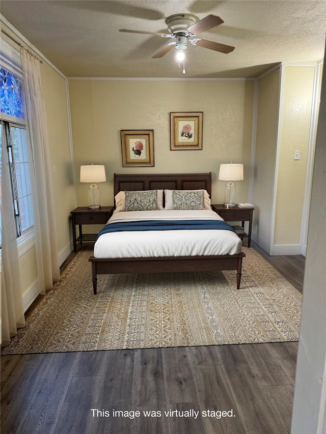 bedroom with dark hardwood / wood-style flooring, a textured ceiling, ceiling fan, and ornamental molding