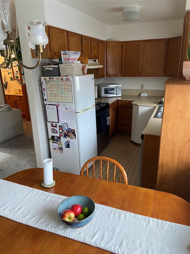 kitchen with dark colored carpet, white fridge, sink, and black electric range