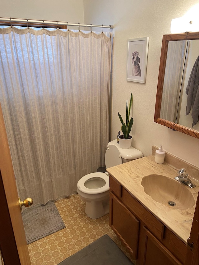 bathroom with vanity, toilet, and walk in shower