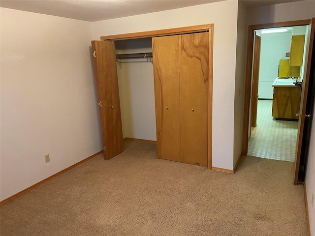 unfurnished bedroom with light carpet and a closet