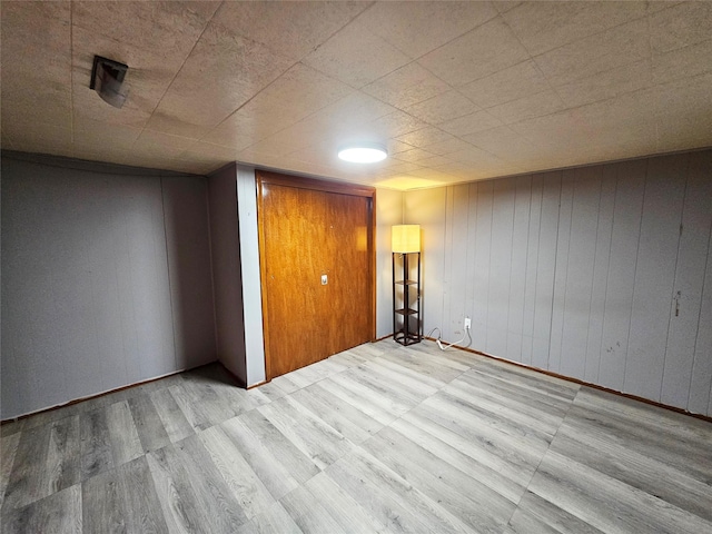 interior space featuring wood walls and light wood-type flooring