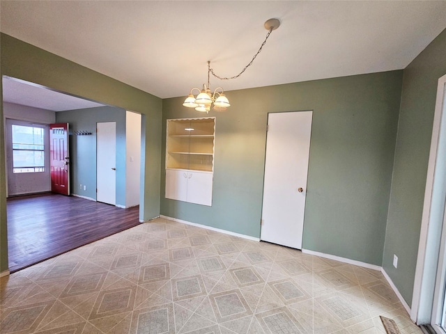 unfurnished room featuring an inviting chandelier