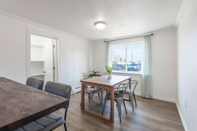 dining room with hardwood / wood-style floors, crown molding, and a textured ceiling