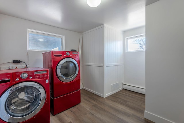 laundry area with baseboard heating, separate washer and dryer, and hardwood / wood-style flooring