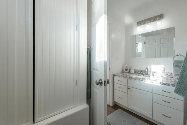 bathroom featuring wood-type flooring, vanity, and shower / bathtub combination