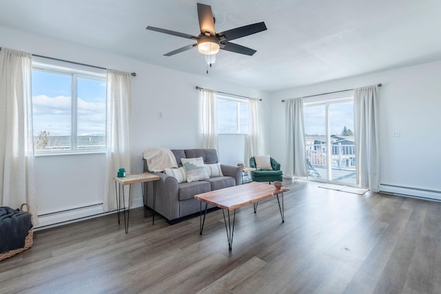 living room featuring wood-type flooring, baseboard heating, and ceiling fan