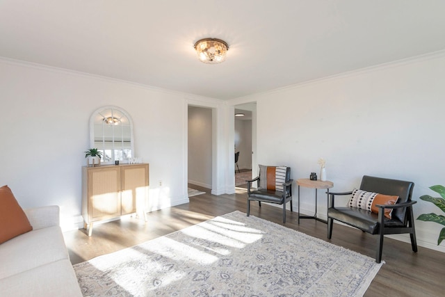 sitting room featuring wood-type flooring and ornamental molding