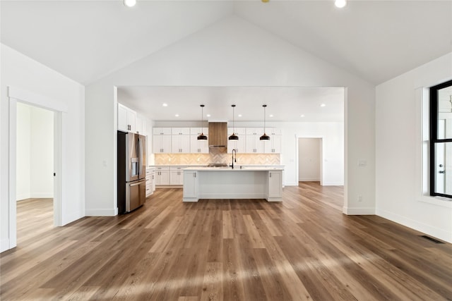 kitchen featuring white cabinetry, light wood-style floors, light countertops, stainless steel refrigerator with ice dispenser, and decorative backsplash