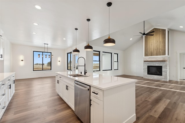 kitchen featuring light countertops, stainless steel dishwasher, a kitchen island with sink, white cabinets, and a sink