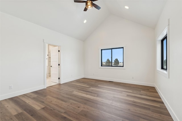 spare room featuring baseboards, ceiling fan, wood finished floors, high vaulted ceiling, and recessed lighting