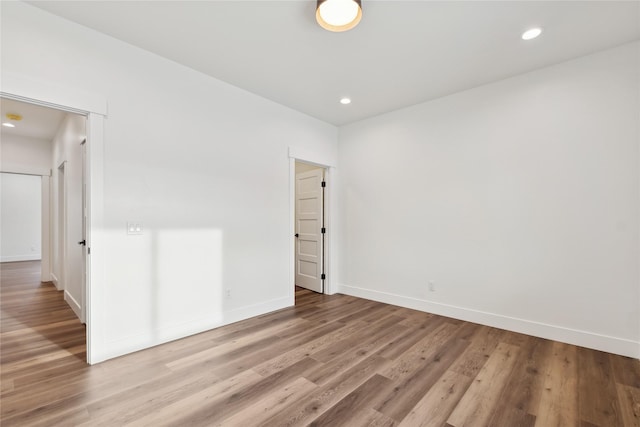 spare room featuring baseboards, wood finished floors, and recessed lighting