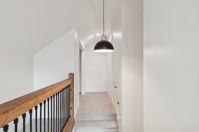 hall featuring lofted ceiling, carpet, and baseboards