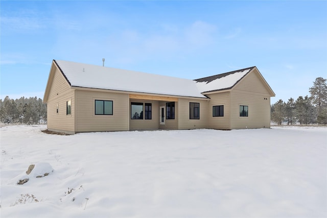 view of snow covered rear of property