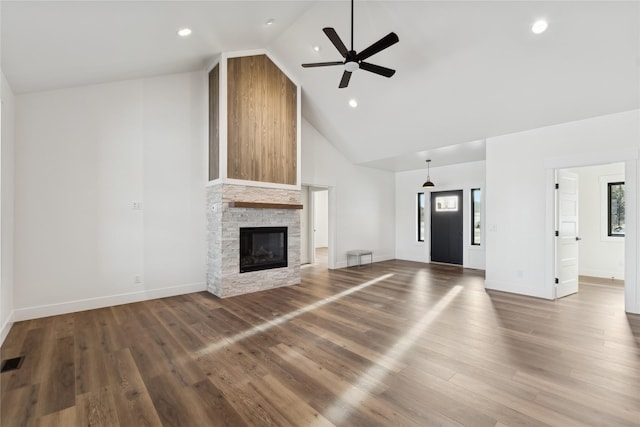 unfurnished living room featuring high vaulted ceiling, a fireplace, wood finished floors, and a wealth of natural light